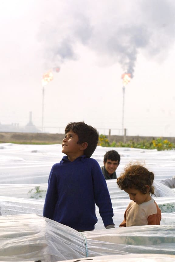 Iraqi children work in a field near al-Rumaila oilfield in the southern Iraqi port of Basra, 645 km south of Baghdad, 11 December 2001.