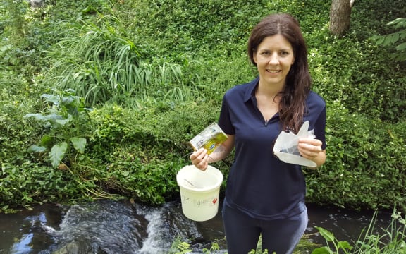 Amanda Valois in Hamilton's Donny Park holding mostly plastic rubbish she picked up along the 100 metre walk from the road to the stream.