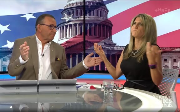 Newshub host Paul Henry and guest Maria Armoudian throw their hands in the air.
