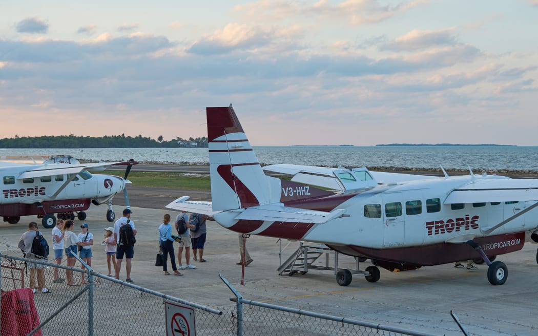 Tourists board a Tropic Air plane at the Sir Barry Bowen Municipal Airport in Belize City on April 17, 2025. A U.S. citizen armed with a knife attempted to hijack a small plane in Belize on Thursday but was shot and killed by a passenger, police said. (Photo by Jose A. Sanchez / AFP)