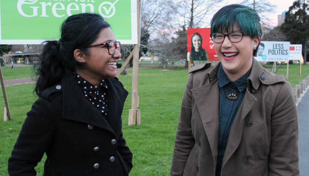 A photo of Saziah Bashir and Fern Seato outside election campaign billboards