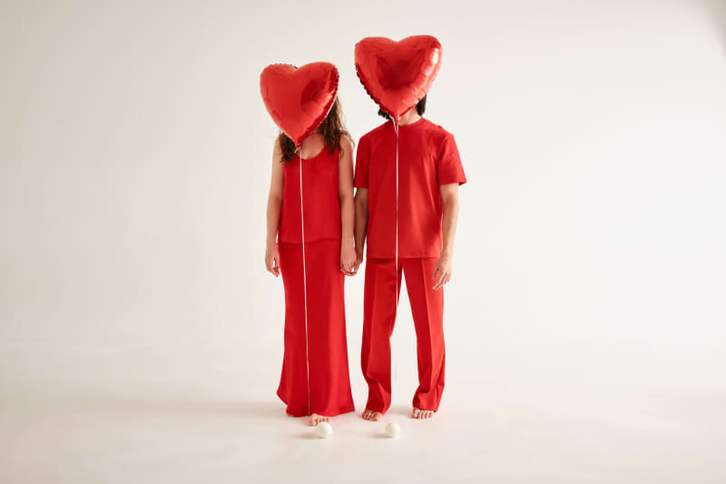 Generic pic for Valentine's Day showing two people dressed in red with red heart-shaped balloons covering their faces