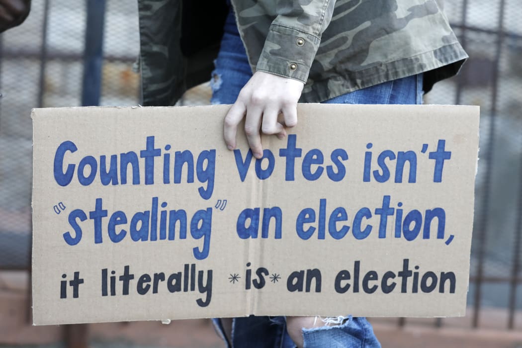 A protestor who wants every vote counted from the 2020 presidential election, carries a sign as they march down Woodward Avenue on November 4, 2020 in Detroit, Michigan.