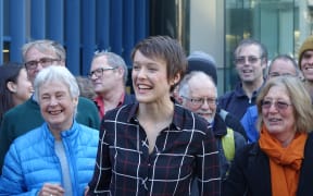 Sarah Thomson, at centre, with supporters outside the High Court in Wellington.