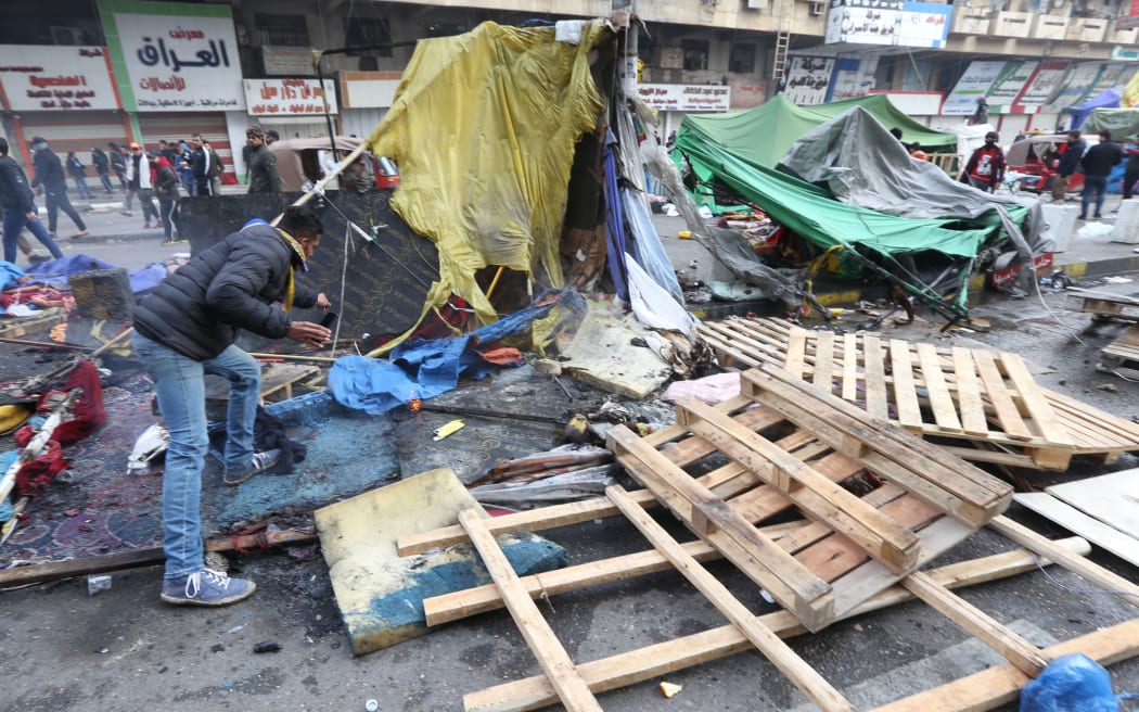 : Iraqi anti-government demonstrators check burnt tents at a protest sit-in at Tahrir Square in the centre of the Iraqi capital Baghdad on January 25, 2020.