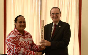 TASANOC Secretary-General and CEO Mrs Netina Latu Vea presents the Tonga baton to British High Commissioner His Excellency Mr. Philip Malone.