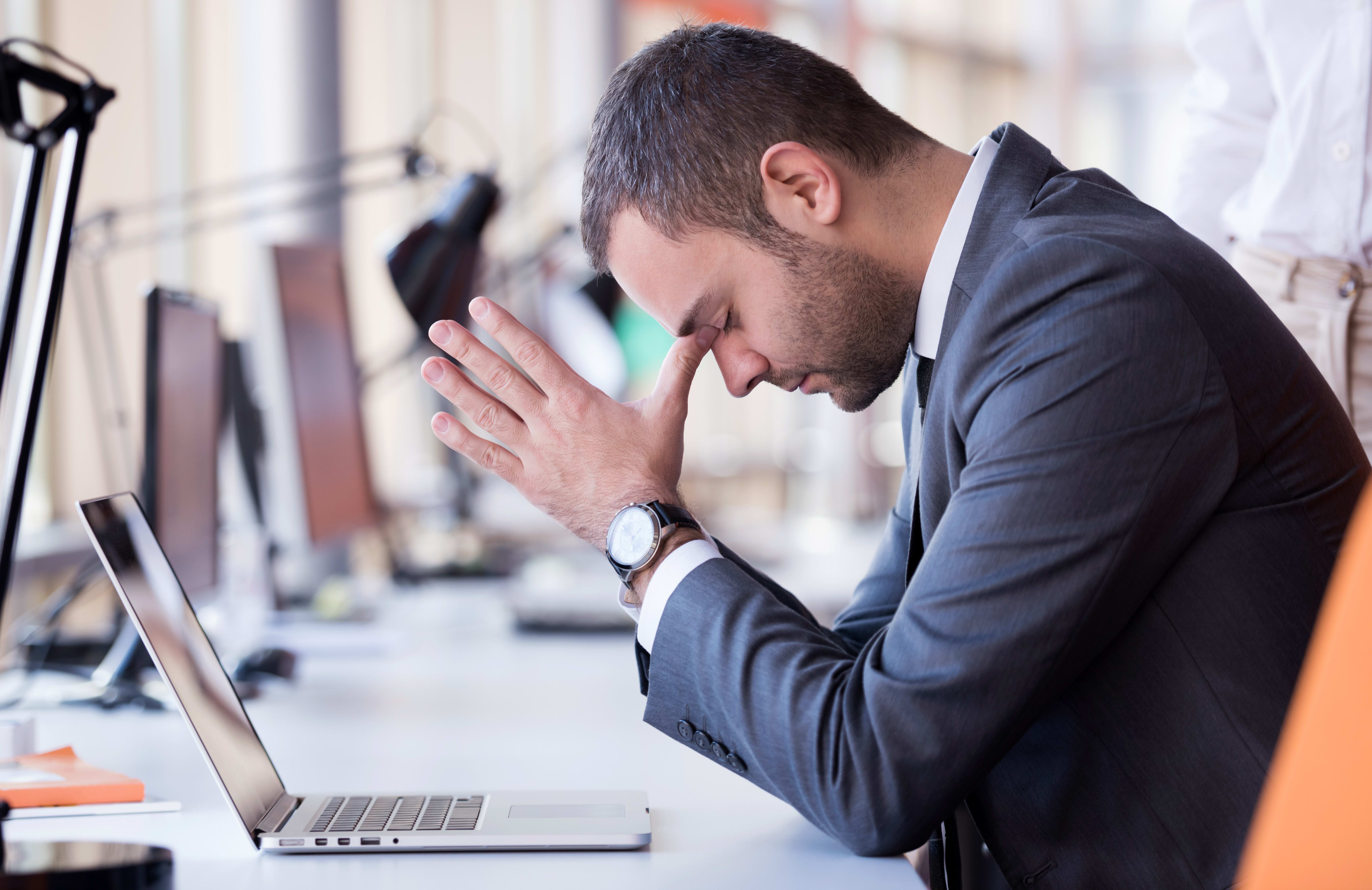 frustrated young business man working on laptop computer at office