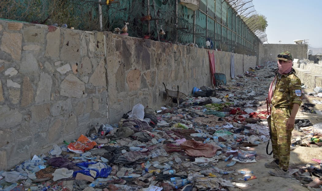 A Taliban fighter stands guard at the site of the August 26 twin suicide bombs, which killed scores of people including 13 US troops, at Kabul airport on August 27, 2021.