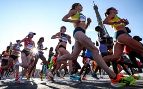 New Zealand's Camille French (C) and the rest of athletes run past Eiffel Tower, as they compete in the women's marathon of the athletics event at the Paris 2024 Olympic Games in Paris on August 11, 2024. (Photo by Anne-Christine POUJOULAT / AFP)