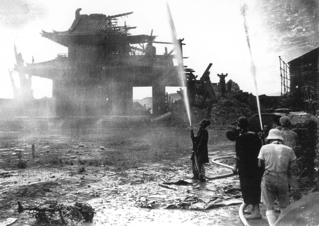 Behind-the-scenes shot of crew using hoses to mimic a downpour for the 1950 film Rashomon