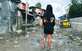 Clara, 14, stands in one of Baseco’s intertwining lanes. She says many girls who live here have become mothers at a young age. Tom Booth/CNN