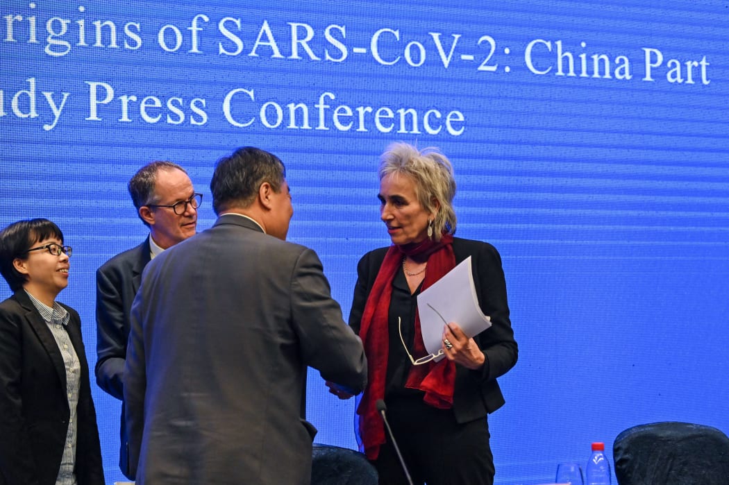 Liang Wannian shakes hands with Marion Koopmans (right) as Peter Ben Embare looks on after a press conference to wrap up a visit by an international team of experts from the World Health Organization (WHO) in  Wuhan.