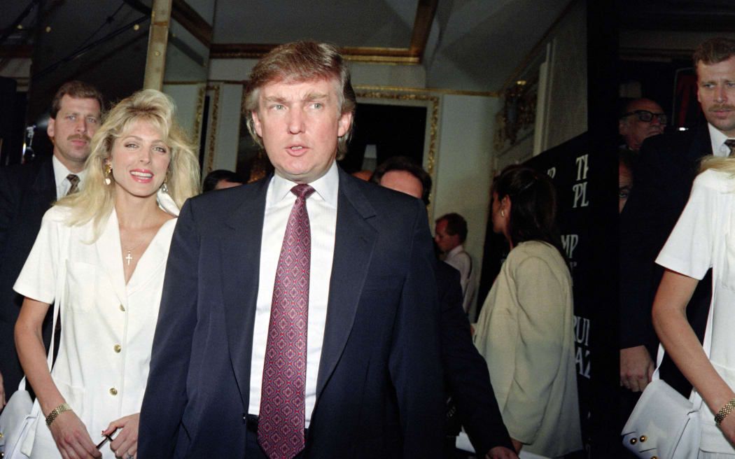 Developer Donald Trump (C) and his fiance Marla Maples walk through the Plaza Hotel on July 9, 1991 in New York. Trump announced the couple engagement on July 3.  AFP PHOTO EVY MAGES (Photo by EVY MAGES / AFP)