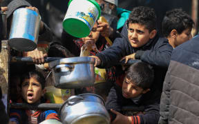 Displaced Palestinians gather to receive food at a donation point in Rafah in the southern Gaza Strip on March 07, 2024, after more than four months of ongoing battles between Israel and the militant group Hamas. UNICEF, the UN Children's Agency, and the UN's World Food Programme have warned Gazans are inching closer towards famine. (Photo by Yasser Qudihe / Middle East Images / Middle East Images via AFP)