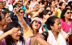 Female demonstrators shout slogans during a protest against India's new citizenship law in Guwahati on December 21, 2019.