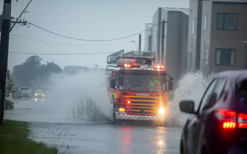 Emergency vehicles making their way through flooded roads in Wellington.