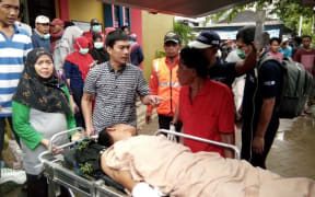 A survivor receives medical treatment at a hospital in Carita on December 23, 2018, after the area was hit by a tsunami on December 22 following an eruption of the Anak Krakatoa volcano.  AFP