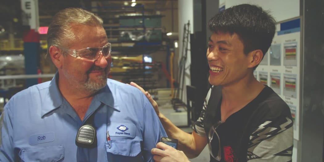Rob Haerr and Wong He bond on the factory floor in the documentary American Factory.