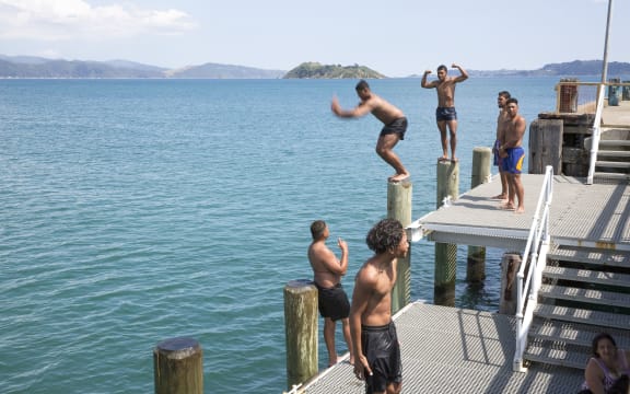 A group of teenagers and kids cooling off at Petone Wharf.