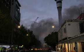 Smoke fills the air as night falls on central city Auckland, where firefighters are battling a blaze at the SkyCity Convention Centre.