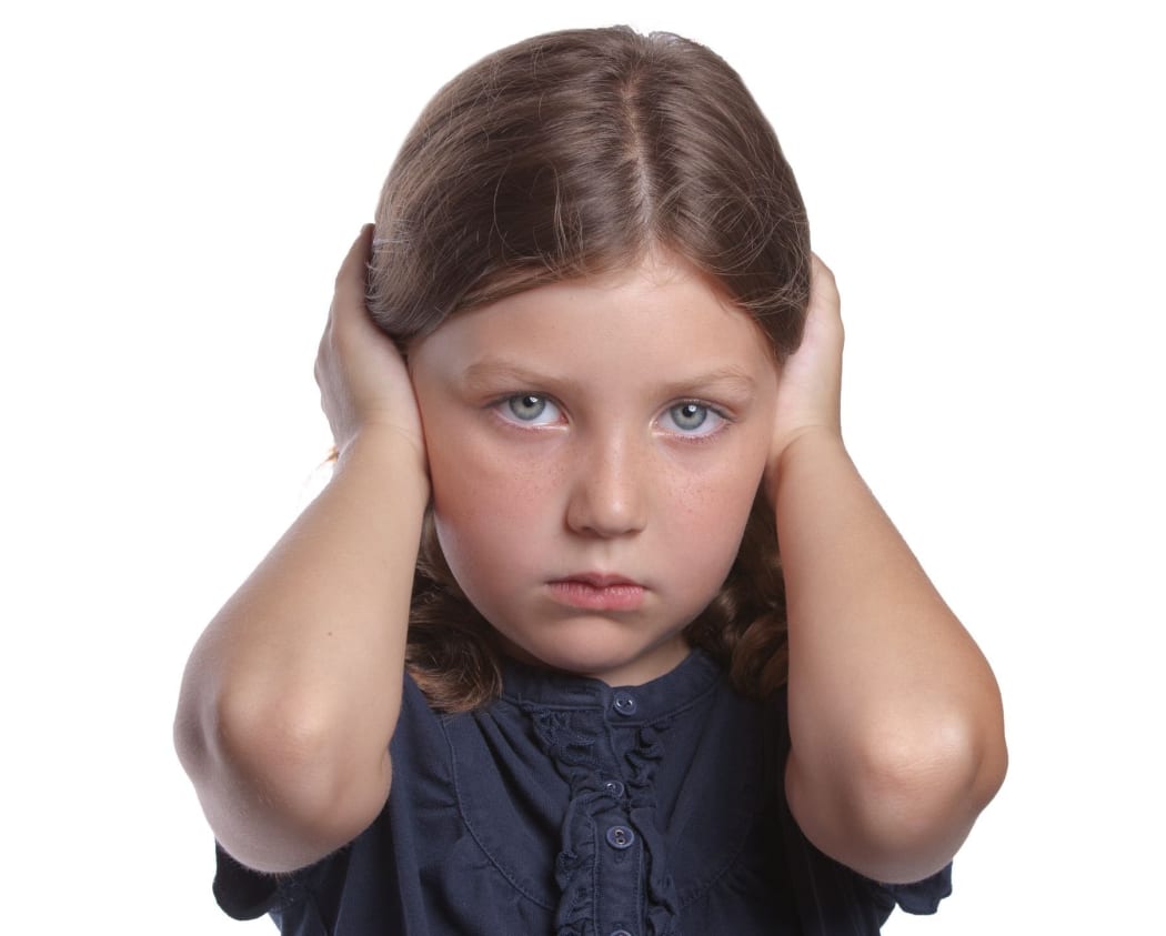 little girl covers ears