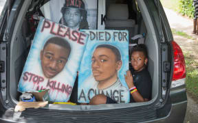A car leaves the memorial service marking the anniversary of Michael Brown's death.