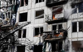 Firefighters work on a fire on a building after bombings on the eastern Ukraine town of Chuguiv on February 24, 2022, as Russian armed forces are trying to invade Ukraine from several directions, using rocket systems and helicopters