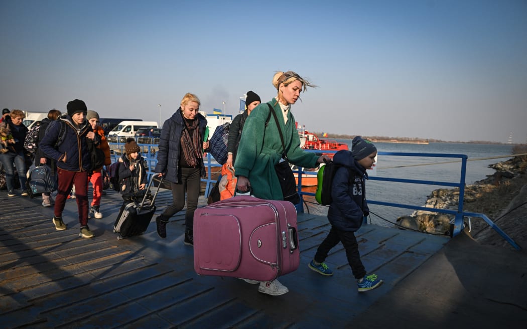 Refugees from Ukraine walk on the jetty after arriving by ferry at the Romanian-Ukrainian border point Isaccea-Orlivka on 24 March, 2022.