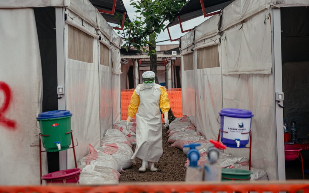 A Doctors Without Borders (MSF) doctor wearing personal protective equipment moves through the isolated red zone to monitor patients, provide medical care, and ensure sanitation of the facility at the Ebola Treatment Center (ETC) in Munigi on June 2, 2026. The sole airport providing humanitarian organisations access to the epicentre of an Ebola outbreak in the Democratic Republic of Congo reopened on June 2, 2026, when the reported number of suspected cases declined.
The country of 100 million people declared on May 15 that it was battling a major epidemic of the highly contagious haemorrhagic fever, prompting the World Health Organization to issue an international health alert. (Photo by Jospin Mwisha / AFP)