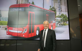 Mayor Phil Goff with an image of the electric bus.
