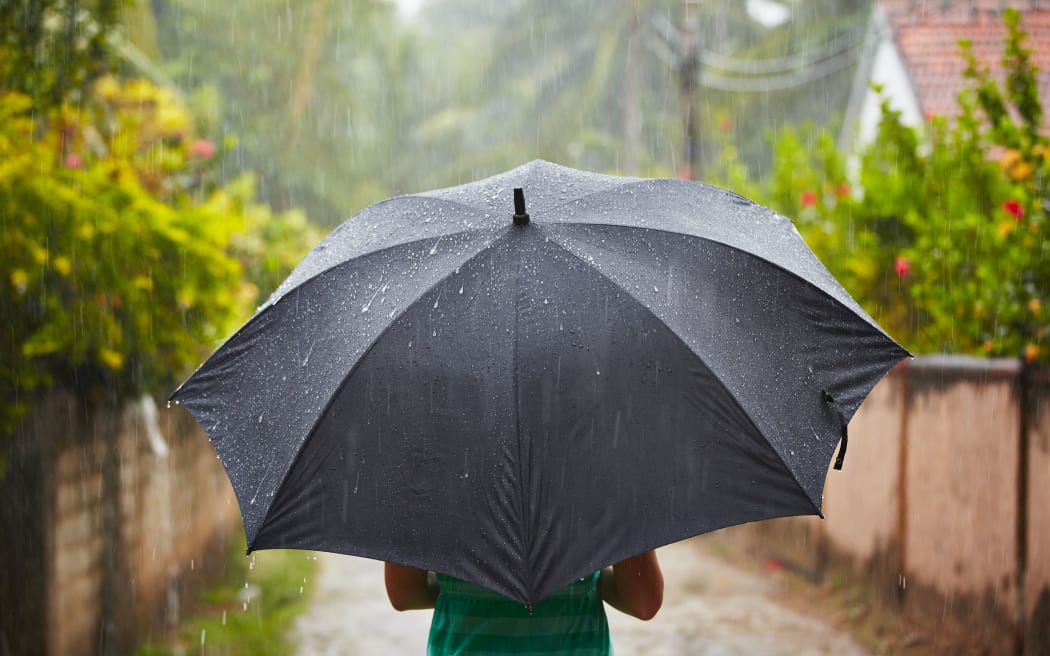 Woman with black umbrella in heavy rain