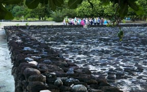 Tour group visits marae at Taputapuatea, on Ra'iatea in French Polynesia.