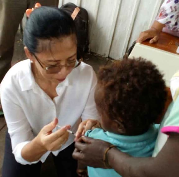 Jane Soepardi vaccinates a child in Asmat.
