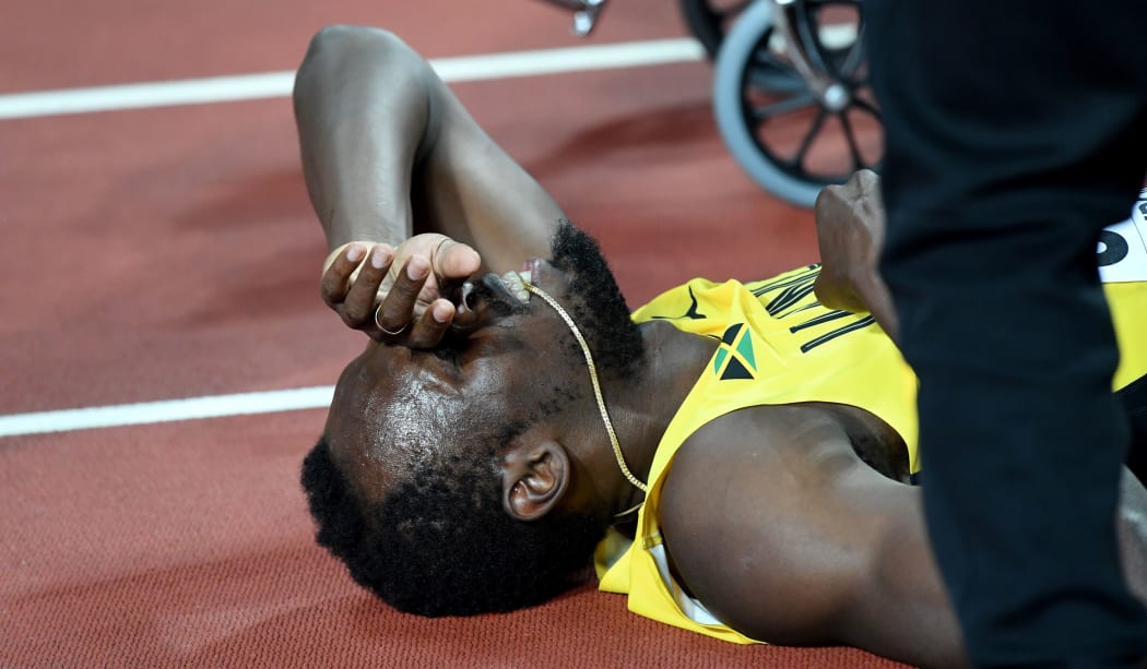 Usain Bolt lays on the track after pulling up injured in the final of the 4x100m relay.