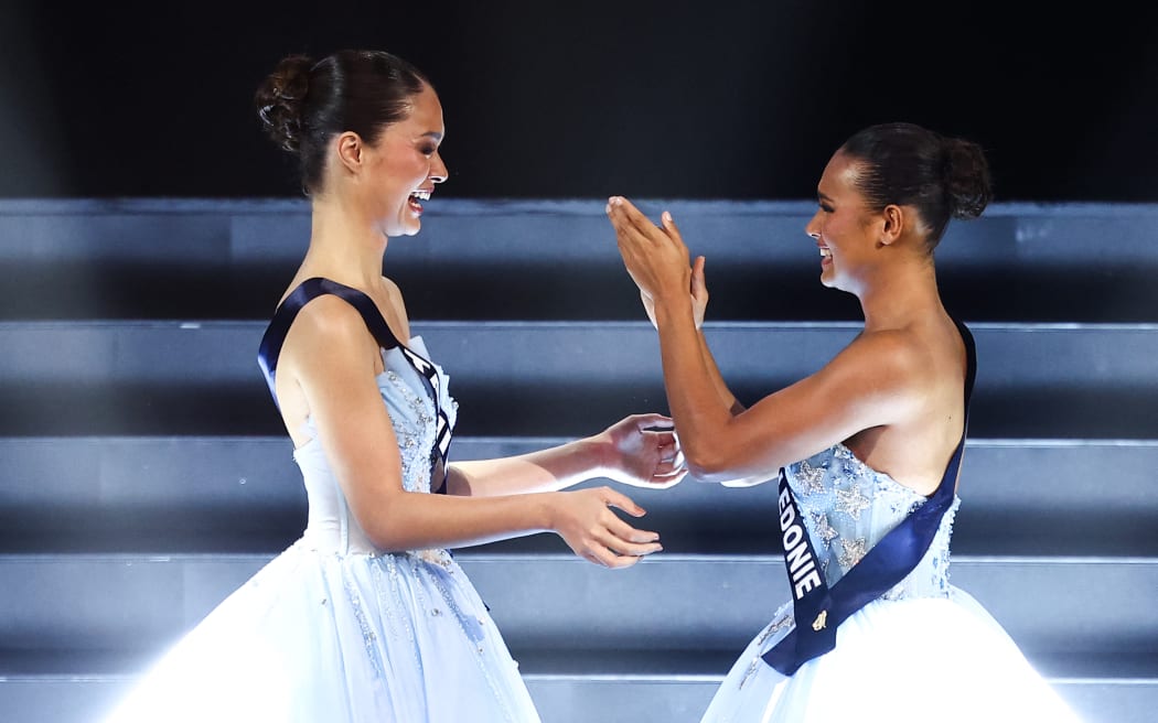 Miss Tahiti Hinaupoko Deveze (L) reacts next to Miss Nouvelle-Caledonie Juliette Collet (R) as she wins during the Miss France 2026 beauty pageant at the Zenith, in Amiens, northern France, on December 6, 2025. (Photo by Sameer AL-DOUMY / AFP)