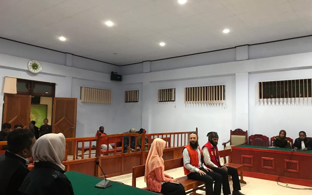 Jakub Skrzypski (L) and Papuan student Simon Magal in court