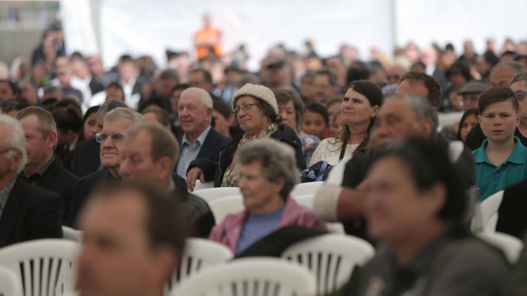 Hundreds of mourners watch the funeral service from the overflow area in a marquee.