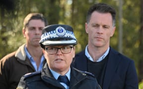 New South Wales premier Christopher John Minns (R) listens to Police Acting Assistant Commissioner Tracy Chapman on a road some 500 meters from the site of a bus crash, where 10 people from a wedding party were killed, in Cessnock, in Australia's Hunter wine region north of Sydney on 12 June, 2023.