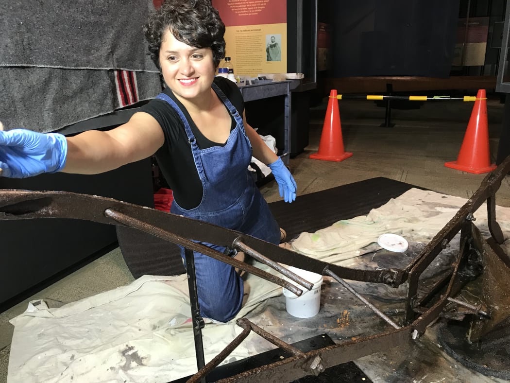 Conservator Mahshid Ezbarami works on the Parihaka plough.