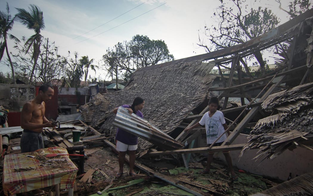 A family salvages roof materials from their destroyed house in Dolores town, Eastern samar.