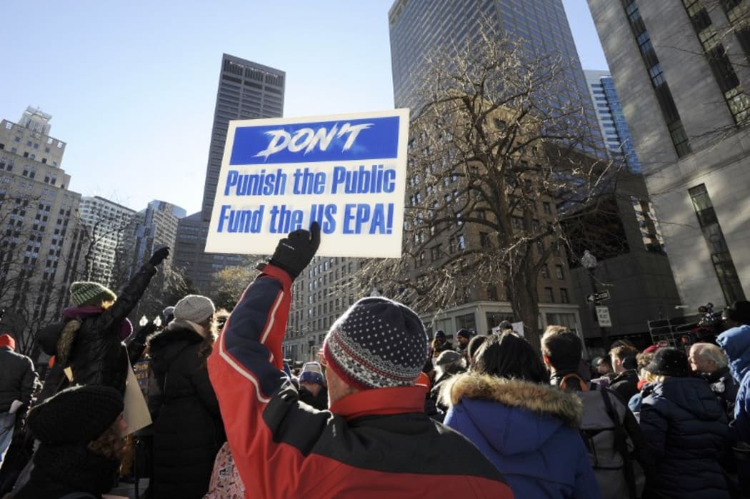 An EPA employee holds a sign during a protest rally by government workers and concerned citizens against the government shutdown on Friday, January 11, 2019 at Post Office Square near the Federal building, headquarters for the EPA and IRS in Boston.AFP