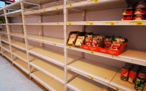 The shelves are almost empty at Foodland Supermarket due to shipping issues.