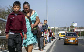 Central American migrants travelling in the "Migrant Via Crucis" caravan walk to their legal counselling meeting in Tijuana, Baja California state, Mexico, on April 28, 2018.