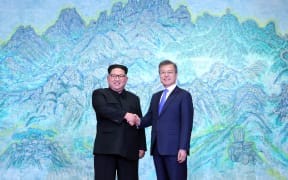 South Korea's President Moon Jae-in (R) shakes hands with North Korea's leader Kim Jong Un (L) during the Inter-Korean summit in the Peace House building on the southern side of the truce village of Panmunjom on April 27, 2018.