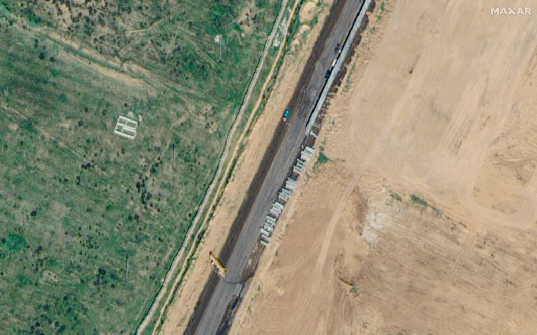 This handout satellite picture taken and released by Maxar Technologies on 15 February, 2024 shows machinery building a wall along the Egypt-Gaza Strip border in Rafah, Egypt.