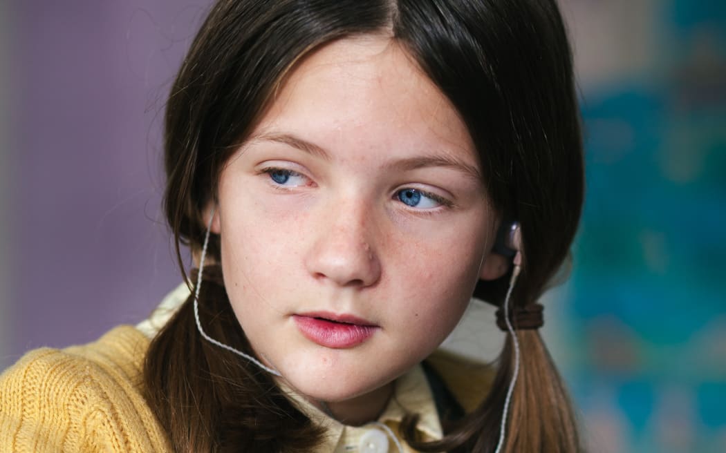 Annette (Natalia Kay) sits at her school desk