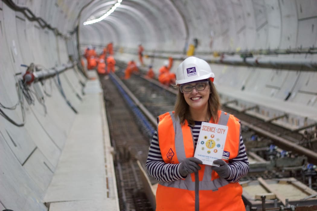 Laurie Winkless and her book in one of London's Cross Rail tunnels being built