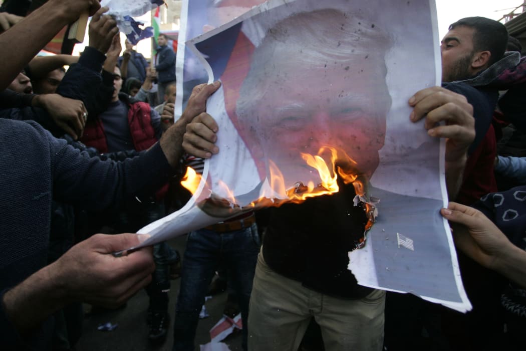 Protesters burn a picture of US President Donald Trump during a protest in the southern Gaza Strip town of Rafah.