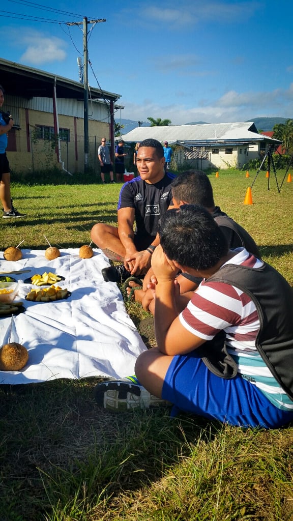 All Black Ofa Tu'ungafasi shares some fruit with local children.