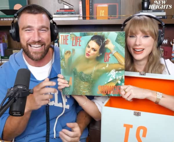 A smiling man and woman hold an album cover.